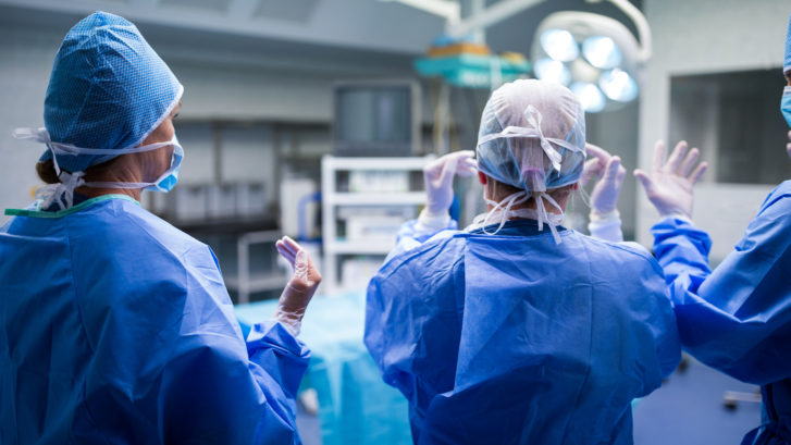 Rear view of surgeons preparing for operation in operation room