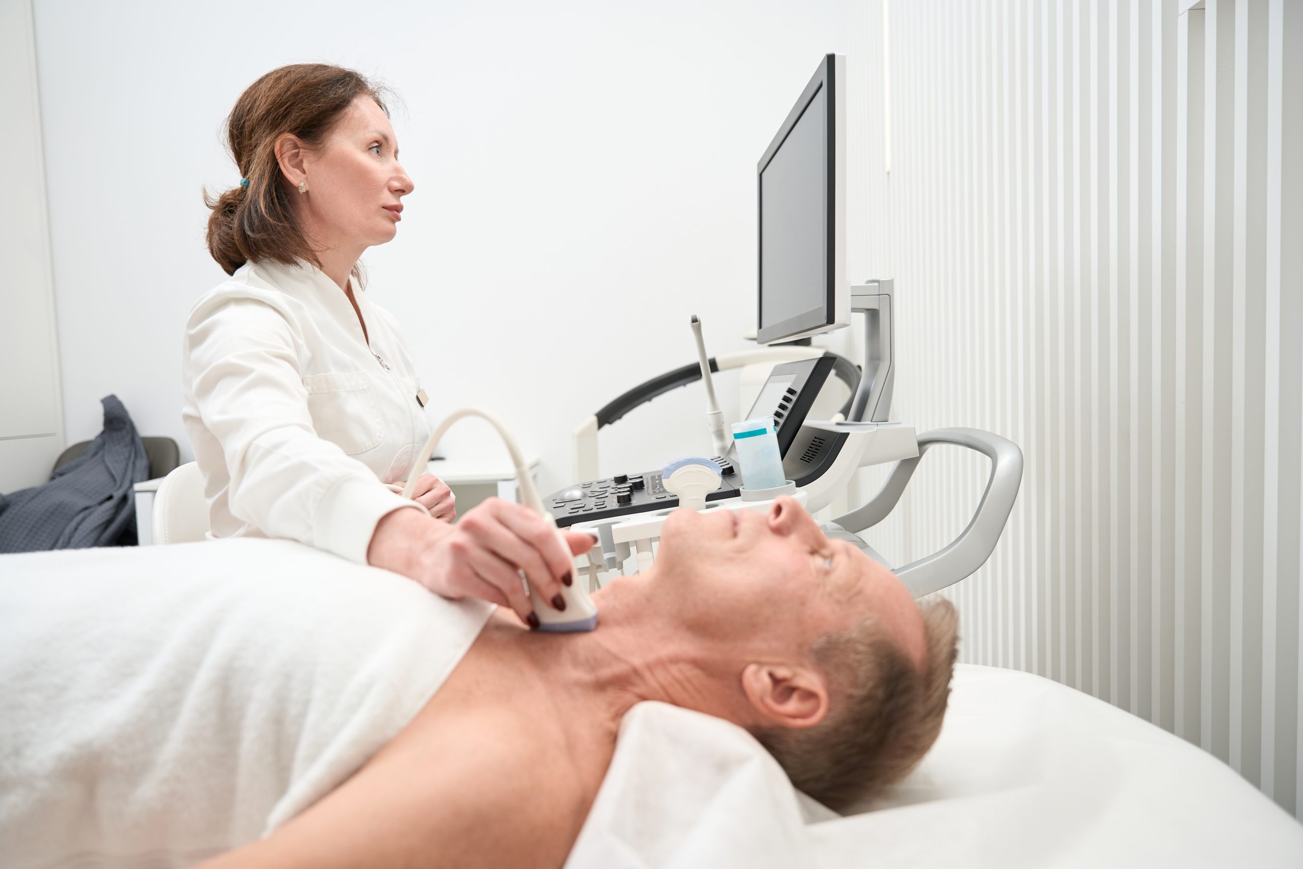 Woman uzist looks at the screen of an ultrasound scanner